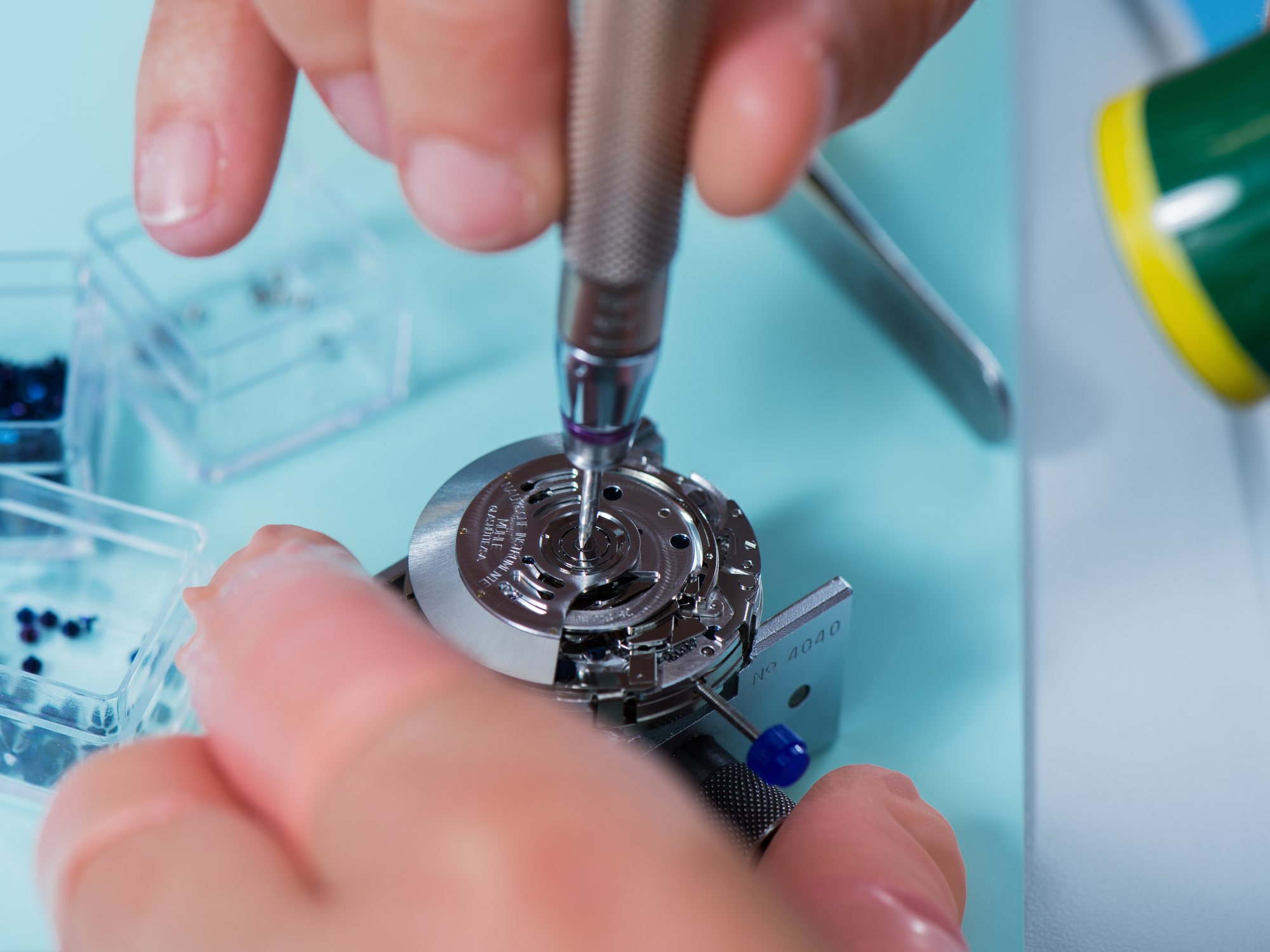 Mühle-Glashütte – Uhrmacherhände montieren einen Rotor auf ein Uhrwerk in der Manufaktur (offizielles Kundenfoto)